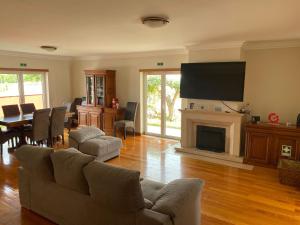 un soggiorno con divano e TV a schermo piatto di Amazing Scorpion´s House Leiria a Leiria