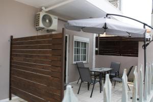 a patio with a table and an umbrella at POSIDONIA RESORT No7 in Nea Vrasna +14 photos