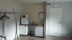 a room with a white refrigerator and a table with a microwave at Guesthouse near Tallinn in Lehmja