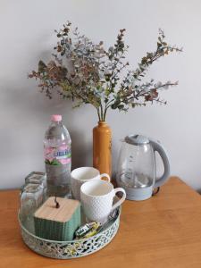 een tafel met een vaas met bloemen en een bord met een vaas bij Viesu nams ADLERI in Saldus