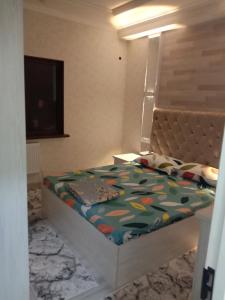 een kleine slaapkamer met een bed met een hoofdeinde bij GREEN HAUS FOR YOU in Sergeli