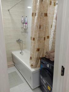 een badkamer met een bad en een douchegordijn bij GREEN HAUS FOR YOU in Sergeli