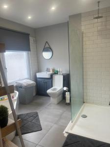 y baño con aseo y lavamanos. en Tredegar property, unique location with luxury bedroom, bathroom & dining room, en Sirhowy