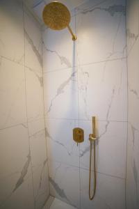 ducha con paredes de mármol blanco y cabezal de ducha en Monseigneur Dijon central & design avec parking, en Dijon