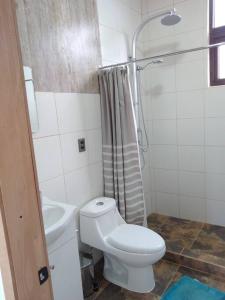 Baño blanco con aseo y lavamanos en Cabaña mirador Quento en 