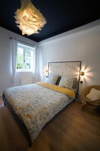 1 dormitorio con cama, ventana y lámpara de araña en Monseigneur Dijon central & design avec parking, en Dijon