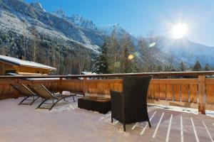 eine Terrasse mit Stühlen und einem Tisch mit Bergen im Hintergrund in der Unterkunft Chalet Isabelle Mountain lodge 5 star 5 bedroom en suite sauna jacuzzi in Chamonix-Mont-Blanc