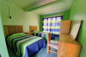 2 łóżka w pokoju z zielonymi ścianami w obiekcie Casa Canseco w mieście Oaxaca