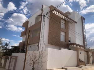 a white building with a brick at Résidence le corail de chat meriem in Sousse