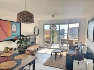 a living room with a table and some chairs at Appartement neuf, Monaco avec vue mer in Beausoleil