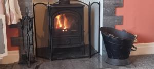 a black fireplace with a bucket next to it at Beechwood House in Keswick