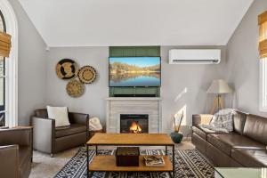 een woonkamer met een open haard en een televisie bij NEW Charming Bright Oak Cabin in Green Valley Lake