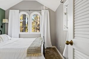 een slaapkamer met een wit bed en 2 ramen bij NEW Charming Bright Oak Cabin in Green Valley Lake