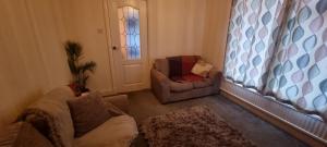 uma sala de estar com um sofá e uma cadeira em Beechwood House em Keswick