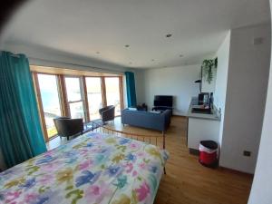 1 dormitorio con 1 cama y sala de estar en CELLAR COVE, en Perranporth