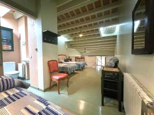 a room with two beds and a chair in a room at Casa/Apartamento Duplex con parking en Palafrugell in Palafrugell