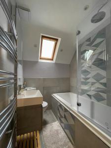 a bathroom with a tub and a sink and a shower at Surrey Hills Lodge in Ewhurst