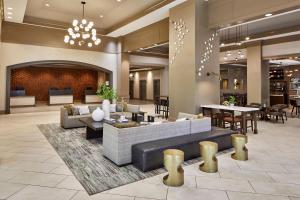 a lobby with a couch and tables and chairs at Atlanta Marriott Alpharetta in Alpharetta