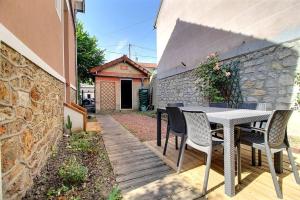 a patio with a table and chairs and a building at Maison familiale - Gare d'Aulnay in Aulnay-sous-Bois