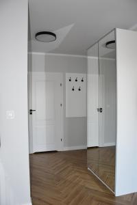 a room with white cabinets and a glass door at Apartament pod zegarem in Giżycko