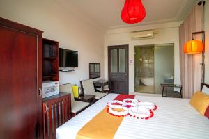 a bedroom with a bed with red decorations on it at The House 36 in Hoi An