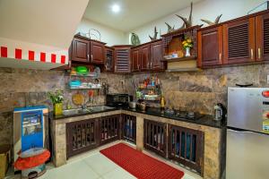 a kitchen with wooden cabinets and a refrigerator at The House 36 in Hoi An