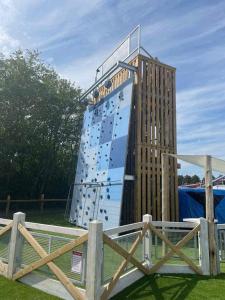 a building with a climbing wall next to a wooden fence at Chestnut grove, Thorpe park in Humberston