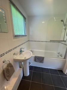 biała łazienka z umywalką, wanną i umywalką w obiekcie Villa 41 Lanteglos hotel w mieście Lanteglos