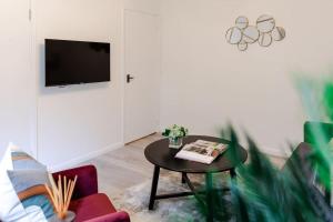 a living room with a table and a tv at Cosy decorated flat in Tonbridge in Tonbridge
