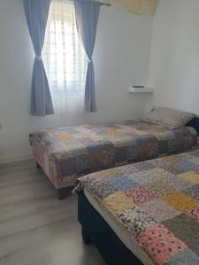 two beds sitting in a room with a window at Mini vacanta in Tăşnad