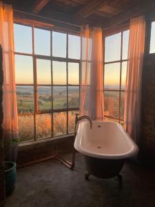 a bathroom with a tub in front of a large window at Infinity at Enfin Estate in Nottingham Road