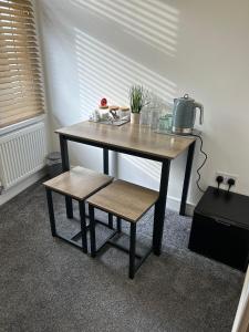 a wooden table with a bench and a table with a table at Tredegar property, unique location with luxury bedroom, bathroom & dining room in Sirhowy