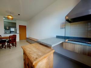a kitchen with a counter and a dining room at Apartamento com piscina aquecida e churrasqueira in Ubatuba