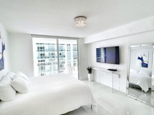 - une chambre blanche avec un grand lit et une télévision dans l'établissement Blissful Sky Residence with Ocean and City Views, à Miami 31 autres photos