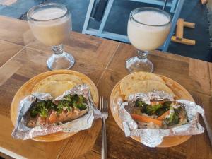 two plates of food on a table with two drinks at Hiker's Home - Hostel Inn in Amecameca de Juárez