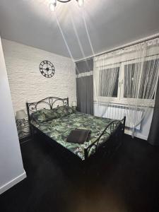 ein Schlafzimmer mit einem Bett und einer Uhr an der Wand in der Unterkunft Zajazd Kasieńka in Orzysz