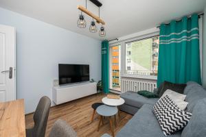 - un salon avec un canapé, une télévision et une table dans l'établissement Apartament Octopus Sopot Kamienny Potok, à Sopot