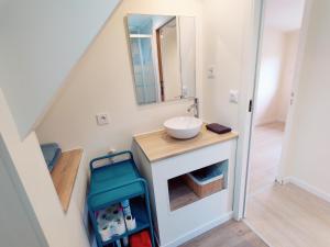 ein Bad mit einem Waschbecken und einem Spiegel in der Unterkunft Maison 50m2 - 2 chambres - Jardin in Fontaine-Étoupefour