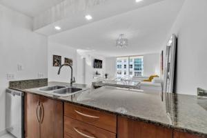 a kitchen with a sink and a refrigerator at Modern Sky Residence with Ocean and City Views in Miami