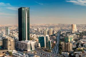 vistas a una ciudad con un rascacielos alto en W Amman Hotel en Amán