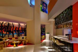 a lobby of a hotel with a bar and chairs at W Amman Hotel in Amman