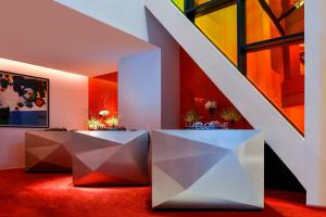 a room with two white tables and a staircase at W Amman Hotel in Amman