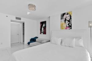 a white bedroom with a bed and a couch at Modern Sky Residence with Ocean and City Views in Miami +55 photos