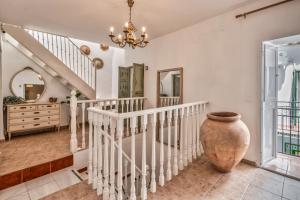 eine Treppe in einem Heim mit einer Vase in der Auster in der Unterkunft Encanto Guesthouse in Canillas de Aceituno