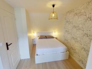 - une chambre avec un lit blanc et une lampe pendant dans l'établissement Maison 50m2 - 2 chambres - Jardin, à Fontaine-Étoupefour