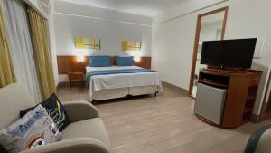 um quarto de hotel com uma cama e uma televisão de ecrã plano em Flat c/ Garagem na Rua Borges Lagoa 1179 UH518 em São Paulo
