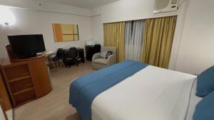 um quarto de hotel com um quarto com uma cama e uma televisão em Flat c/ Garagem na Rua Borges Lagoa 1179 UH518 em São Paulo