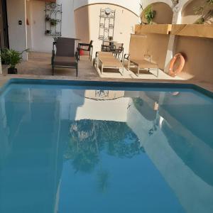 una piscina blu con sedie e tavolo di Grand Hotel Colonial Cancun a Cancún