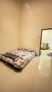 1 dormitorio con cama y espejo en Rumah Yosua, en Palbapang