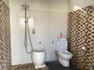 ein Bad mit einer Dusche und einem WC. in der Unterkunft Rumah Yosua in Palbapang